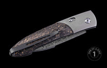 Closed automatic folding knife with textured dark brown handle featuring golden cracks, silver bolster, and patterned Damascus blade, angled side view.