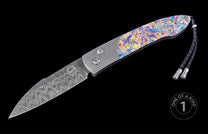 Auto knife with a patterned Damascus blade, vibrant iridescent multi-color handle, and braided black leather lanyard, with 'ONE OF A KIND 1' graphic.