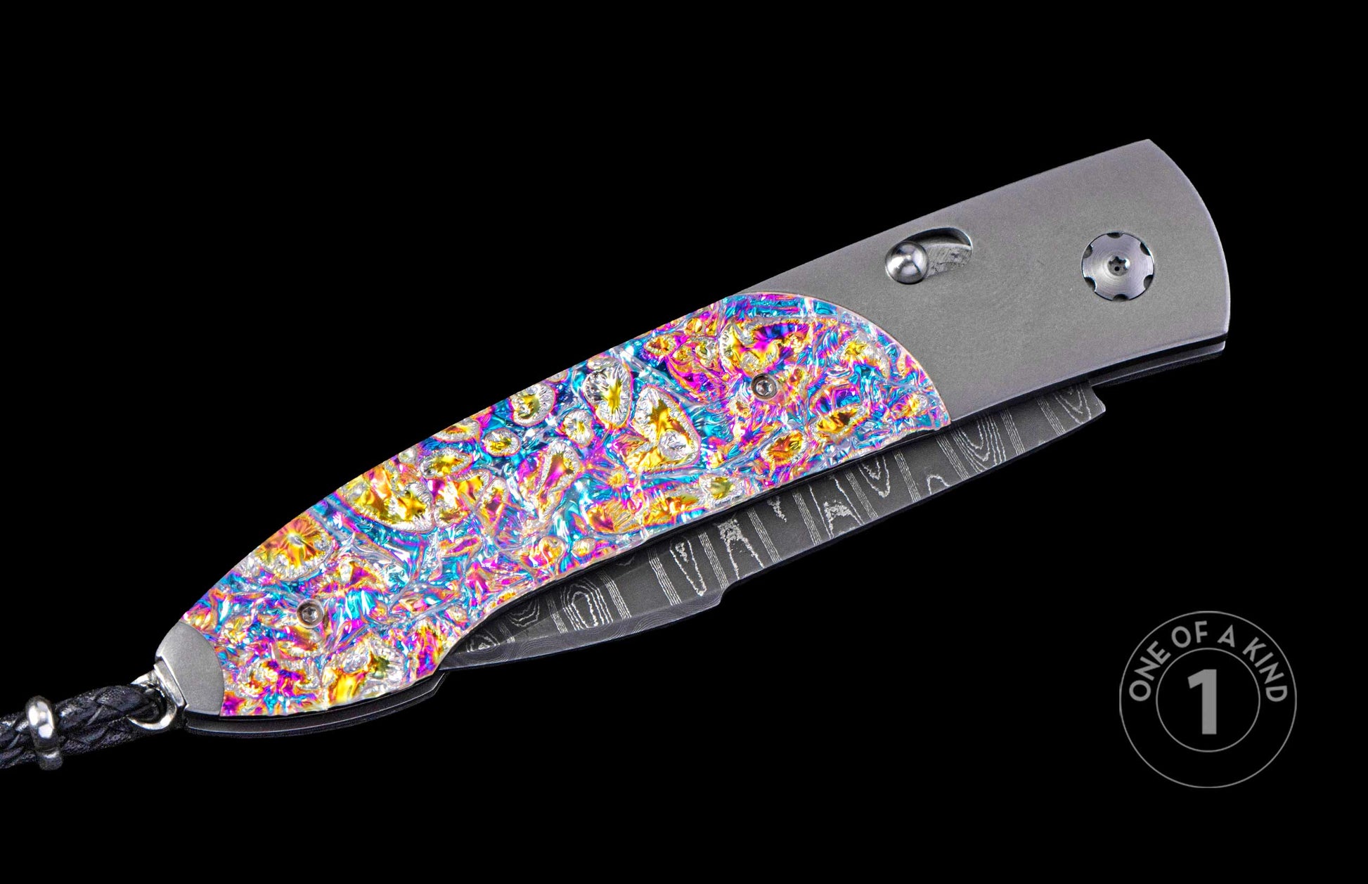 Automatic folding knife with a vibrant iridescent, textured handle inlay, a dark patterned blade, brushed silver frame, and braided leather lanyard.
