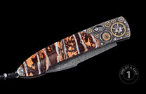 Steampunk folding knife with a banded brown and white handle, Damascus blade, and intricate gear-decorated bolster.