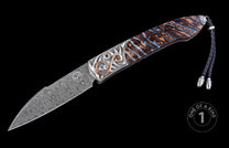 Folding knife with a Damascus steel blade, intricate silver-toned bolster with copper swirls, and unique dark brown and blue scales, featuring a braided leather lanyard.