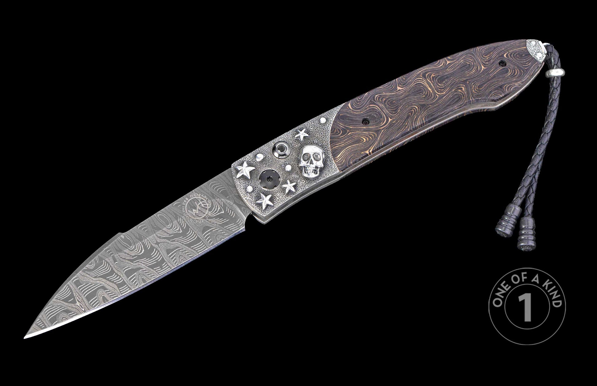 Damascus steel folding knife with a textured silver handle featuring a skull and stars, a swirled wood inlay, and a braided leather lanyard.