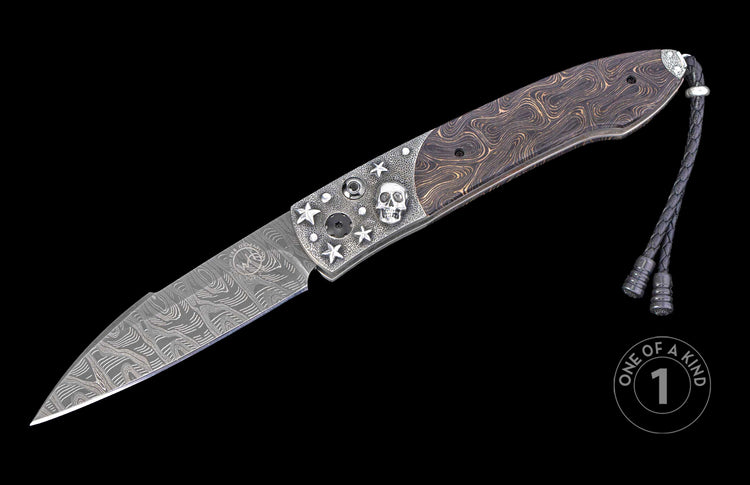 Damascus steel folding knife with a textured silver handle featuring a skull and stars, a swirled wood inlay, and a braided leather lanyard.