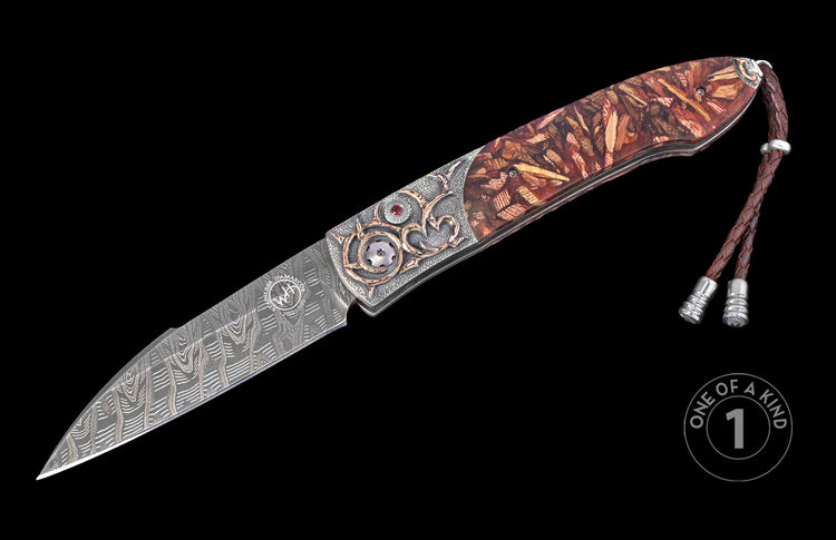 Folding knife with Damascus steel blade, ornate silver and rose gold-accented handle, red gemstone, wood inlay, and braided leather lanyard.