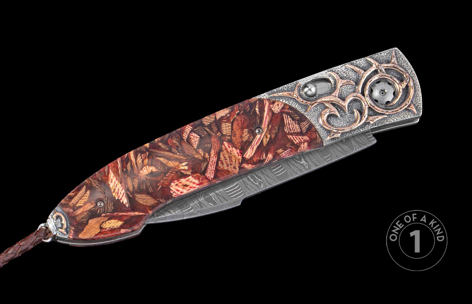 Ornate folding knife with a mosaic wood handle, silver textured bolster with rose gold accents, Damascus steel blade, and braided leather lanyard.