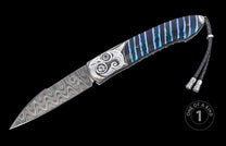 Damascus steel knife with a wavy blade pattern, ornate silver handle with a blue gem, blue striped scales, and braided leather lanyard.