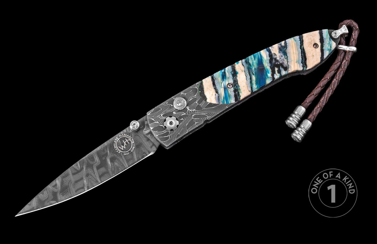 Damascus steel knife with marbled blue and beige handle by Wharncliffe, featuring braided leather lanyard and engraved blade, side view