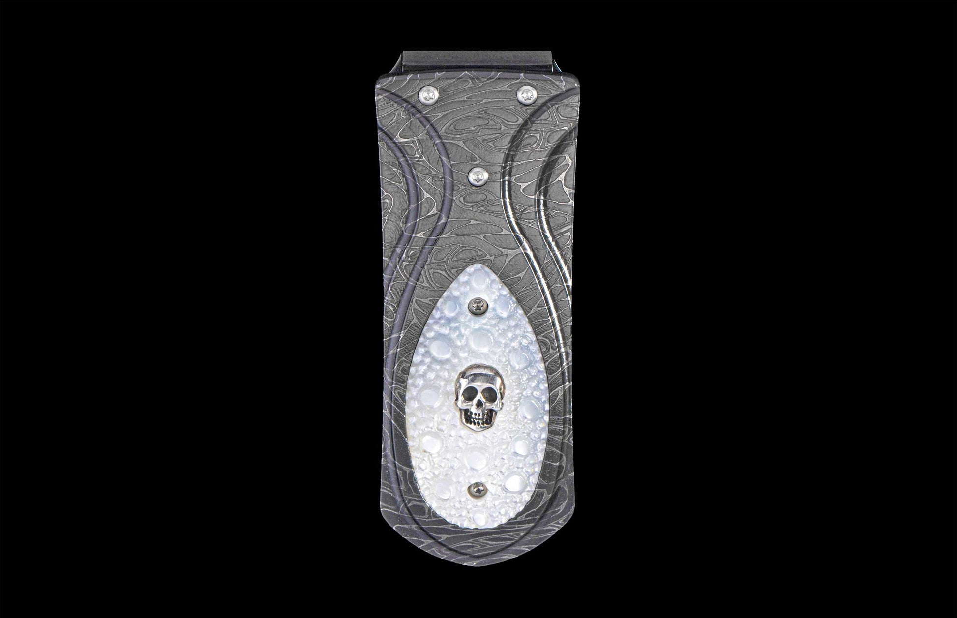 Dark gray money clip with a damascus pattern and a white inlay featuring a silver skull.