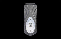 Dark gray money clip with a damascus pattern and a white inlay featuring a silver skull.