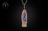 Ornate knife pendant with bronze-toned metal, intricate knotwork, dendritic stone inlay, diamonds, and a silver chain, labeled 'ONE OF A KIND'.