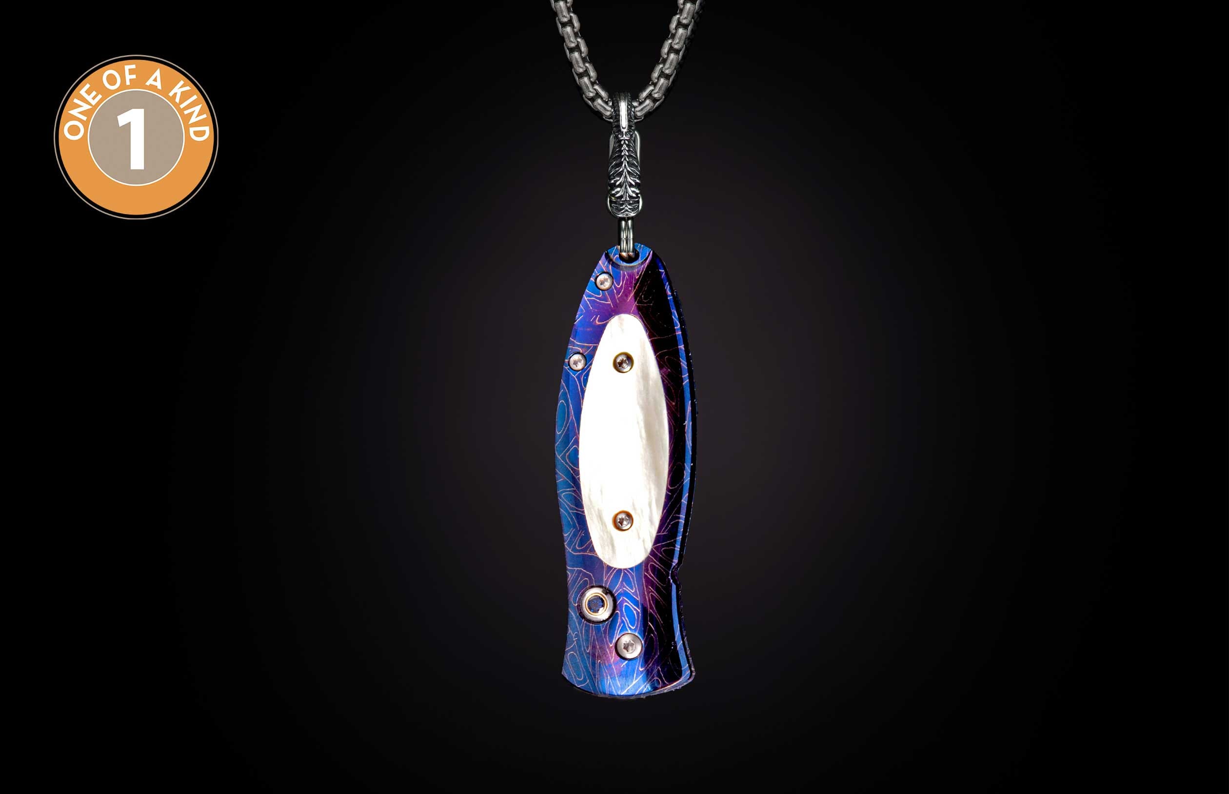 Blue and purple patterned knife pendant hanging from a silver chain with a white oval insert.