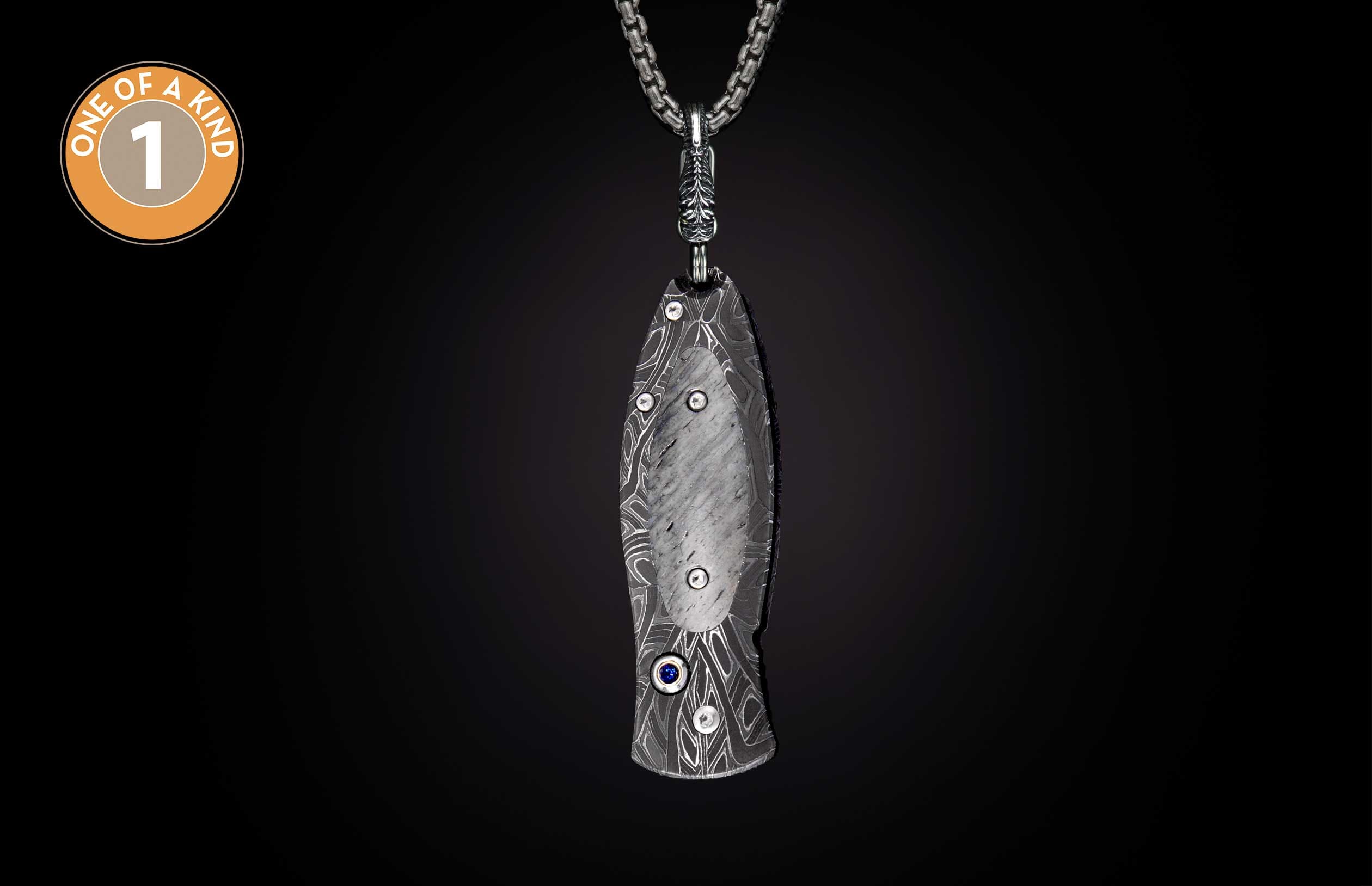 One-of-a-kind Damascus steel knife pendant with a stone inlay, a blue gem, and a linked silver chain.