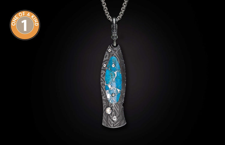 Sleek metal knife pendant with swirling Damascus pattern and bright blue turquoise inlay, hanging from a metal chain.