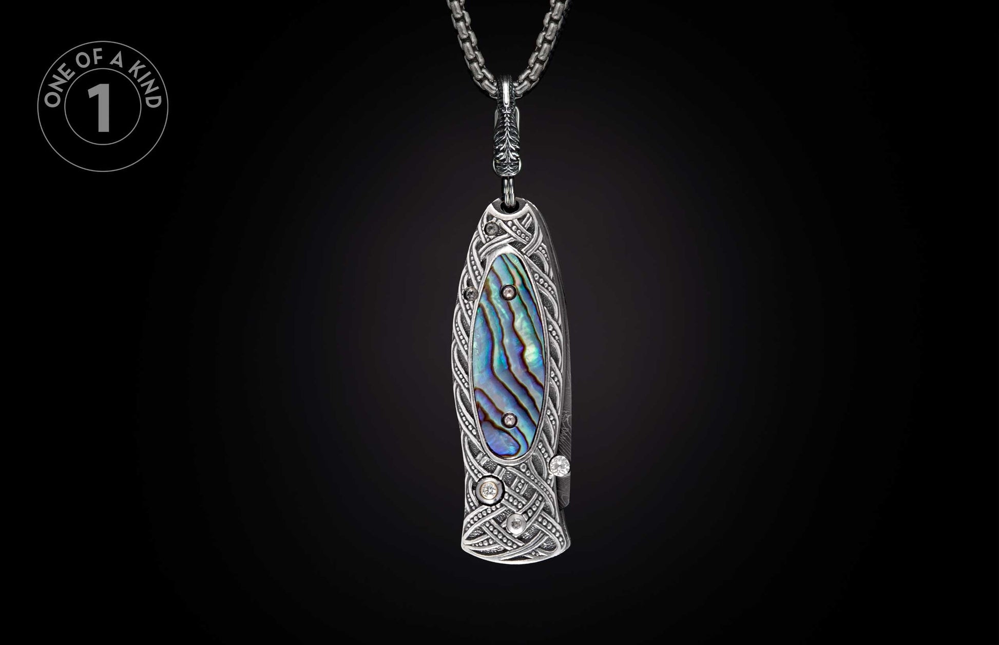 Ornate silver-toned pendant knife with abalone inlay, intricate Celtic knot engraving, and sparkling gemstones.
