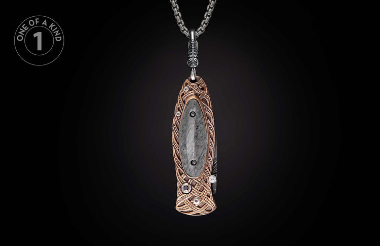 Ornate knife pendant featuring a gray stone inlay and bronze Celtic knotwork design on a silver chain.