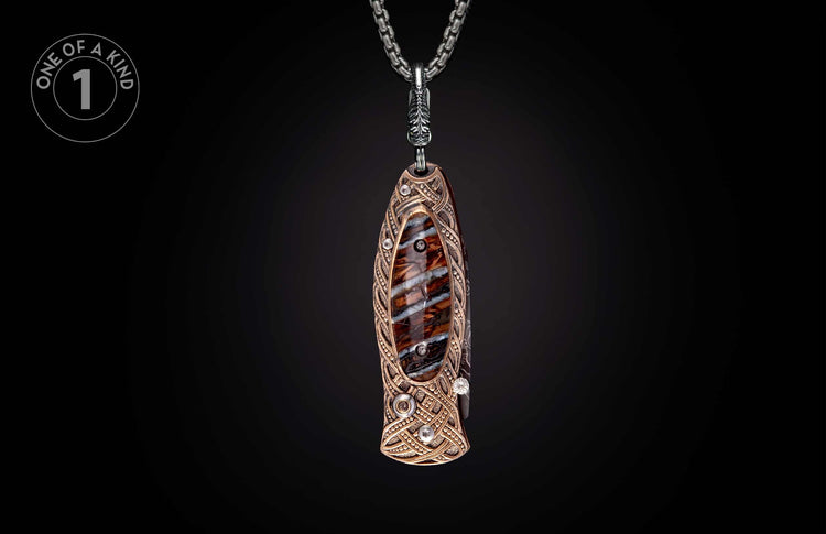 Ornate knife pendant featuring brown and white striped stone inlay, bronze Celtic knotwork, and clear stones on a silver chain.