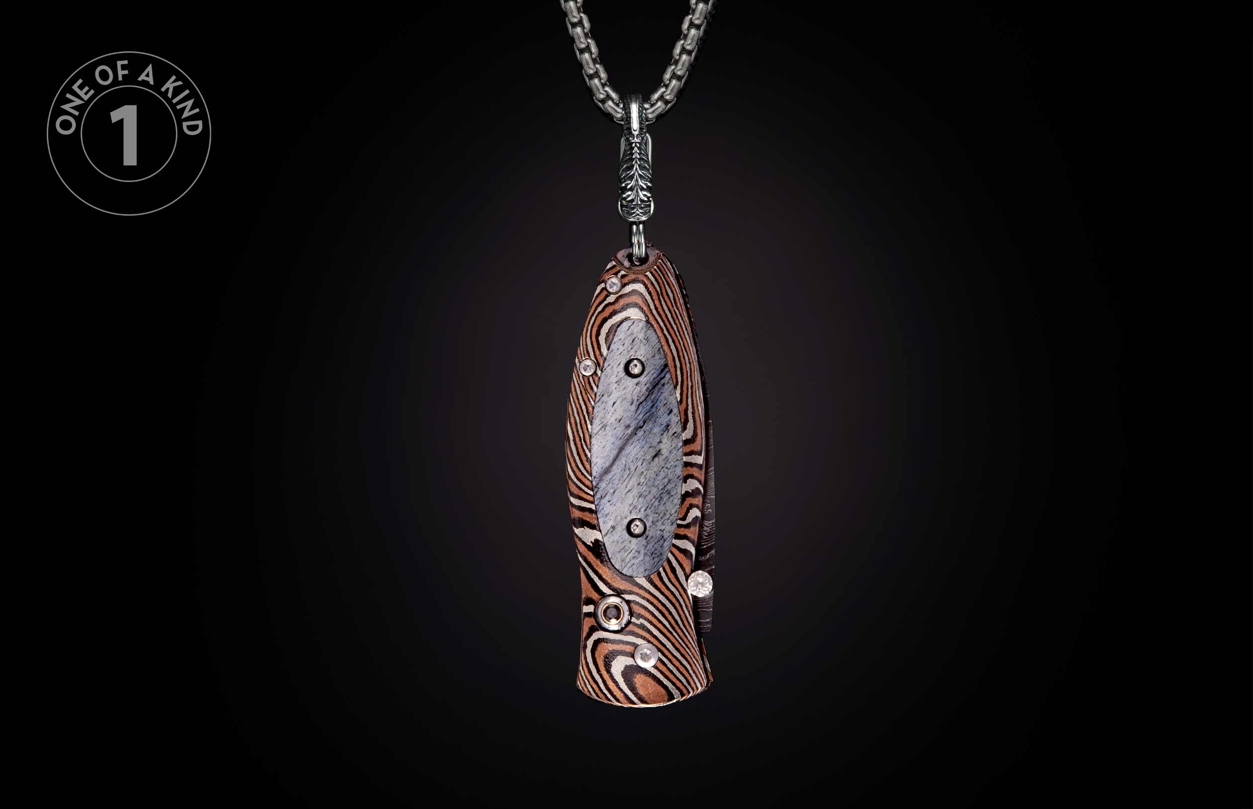Decorative knife pendant with striped handle and grey inlay, embellished with clear stones, hanging from a silver chain.