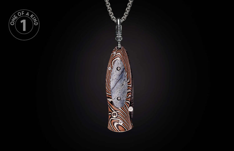 Decorative knife pendant with striped handle and grey inlay, embellished with clear stones, hanging from a silver chain.