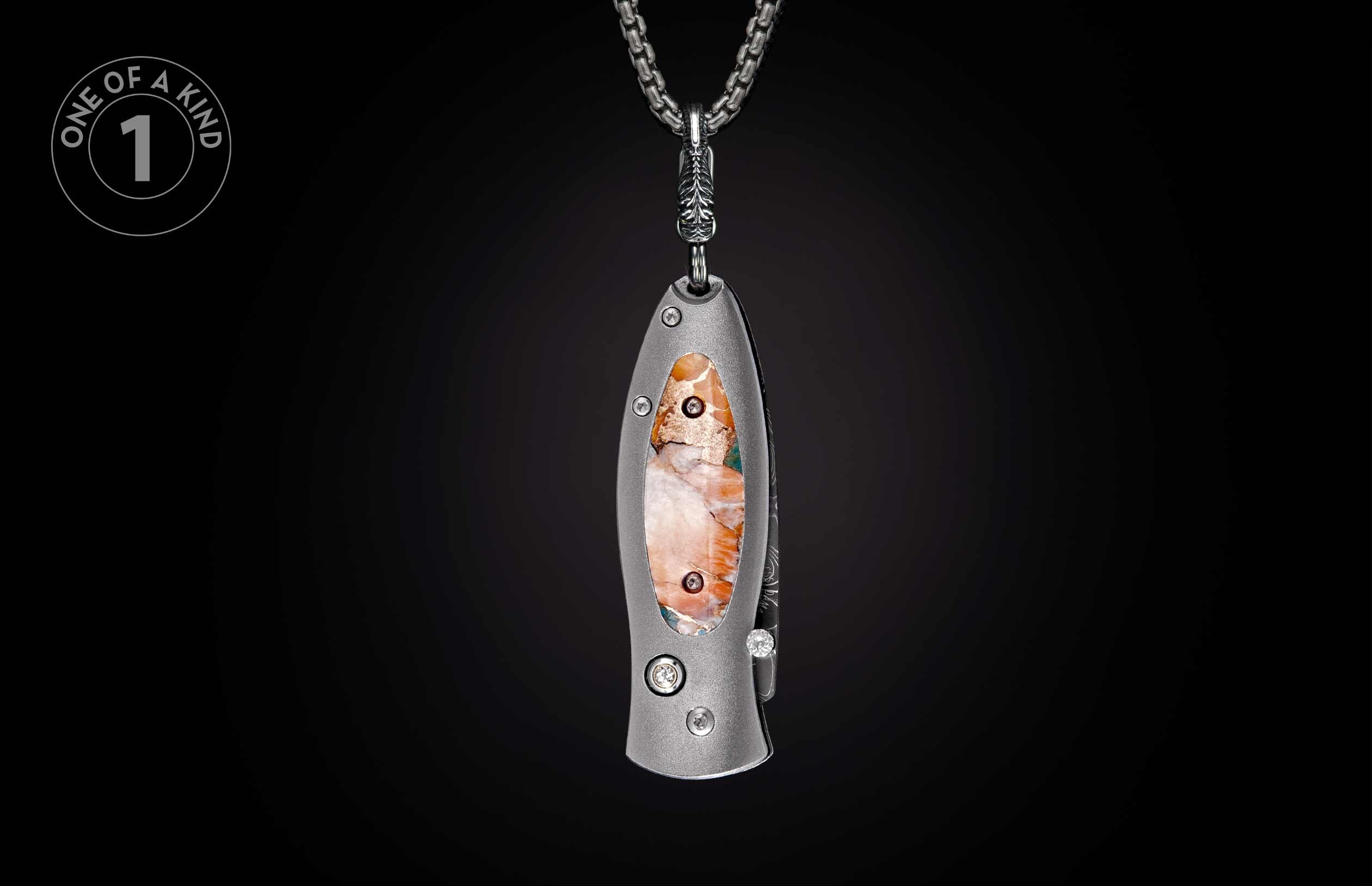 Unique grey metal knife with an orange and white marbled stone inlay and two diamonds, hanging from a silver chain.