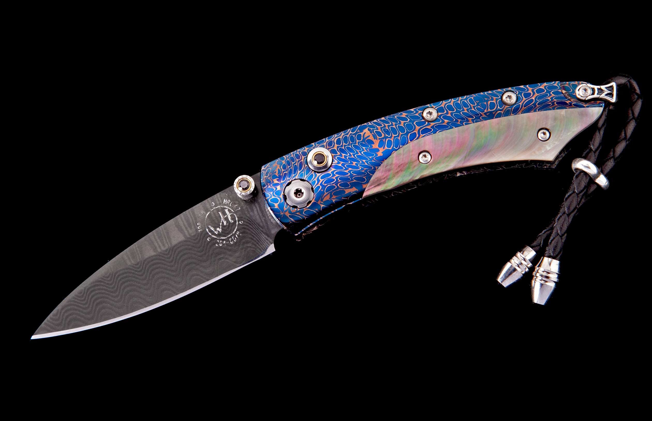 Folding knife with Damascus steel blade, blue and copper patterned handle, iridescent mother-of-pearl inlay, and black braided leather lanyard.