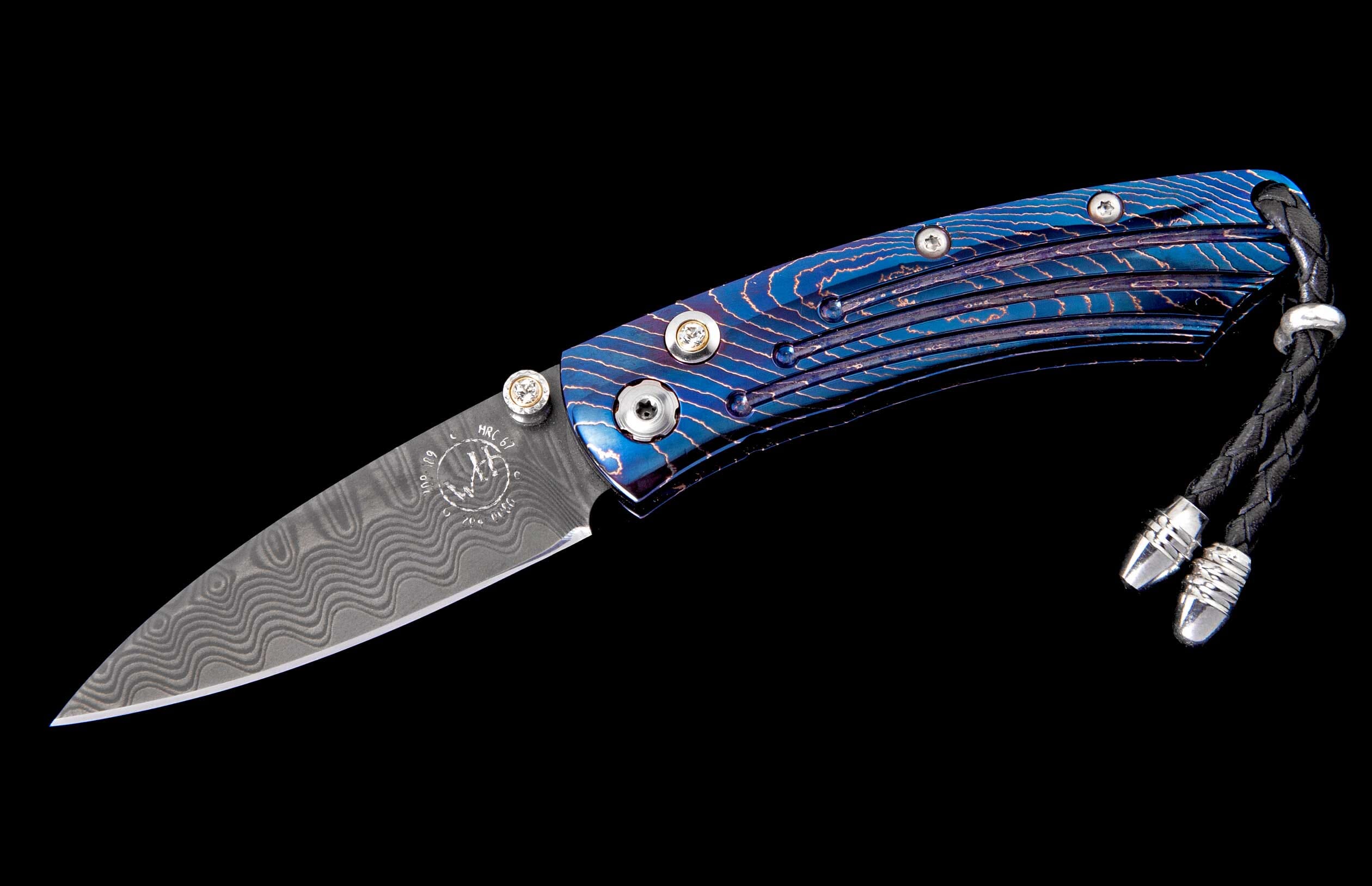 Folding knife with a textured blue and purple handle, a wavy Damascus blade with a 'W' logo, and a black leather lanyard.