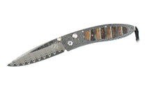 Knife with wavy Damascus steel blade and handle, accented by segments of natural wood, textured grey material, and a black lanyard.