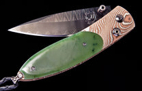 Green jade and copper damascus folding knife by Gump's with a wavy patterned damascus steel blade, partially open.