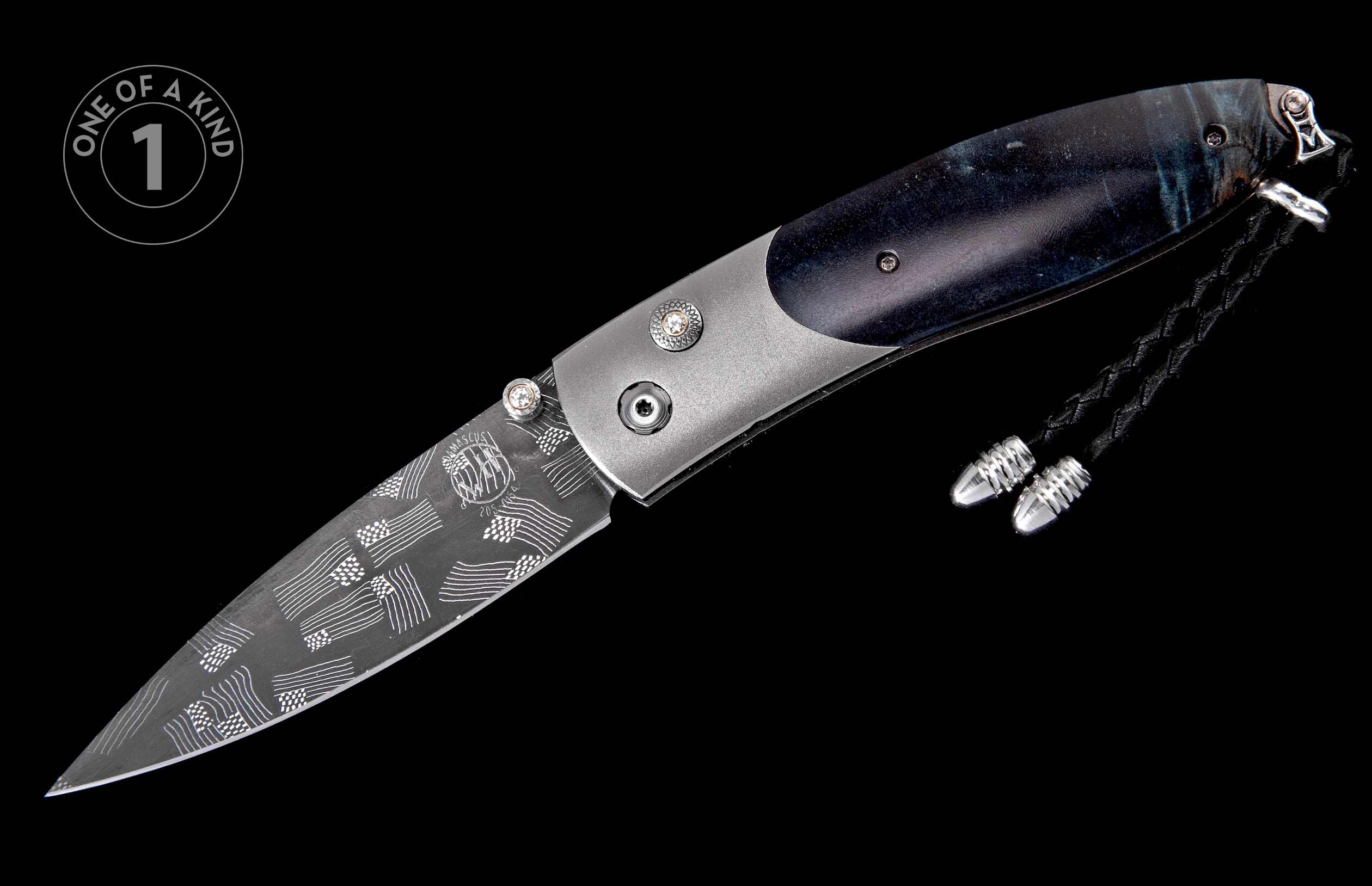 Folding knife with a damascus blade featuring flags and lines, a marbled dark handle with gem-set studs, and a braided lanyard.