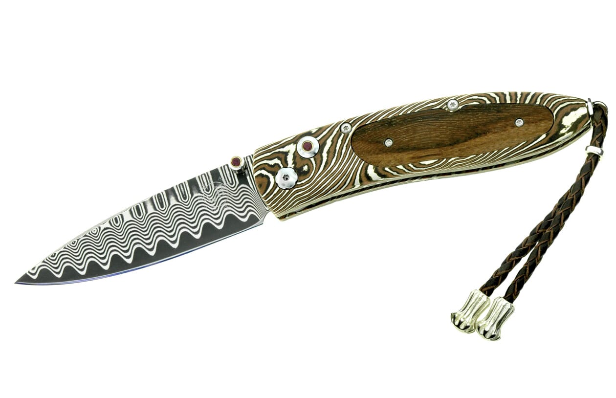 Folding knife with Damascus wavy pattern blade and handle, dark wood inlay, red jeweled pins, and a braided leather lanyard.