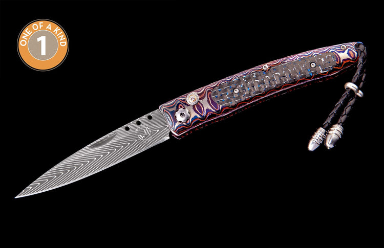 Folding knife with Damascus blade and multicolored handle, featuring a carbon fiber inlay, braided leather lanyard, and "One of a Kind" badge.