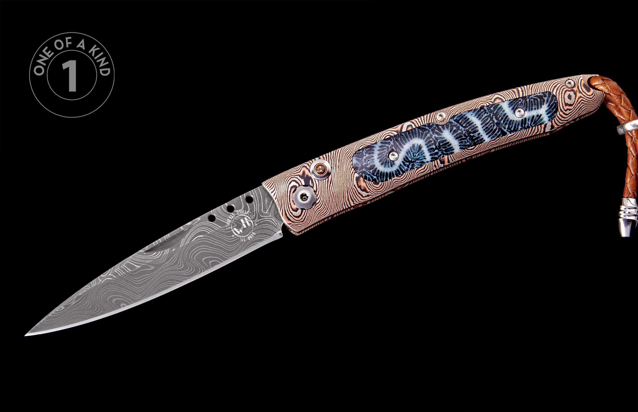 Folding knife with a Damascus steel blade, patterned handle, blue fossil coral inlay, and a braided leather lanyard.