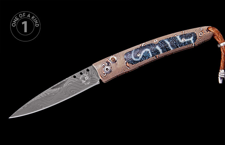 Folding knife with a Damascus steel blade, patterned handle, blue fossil coral inlay, and a braided leather lanyard.
