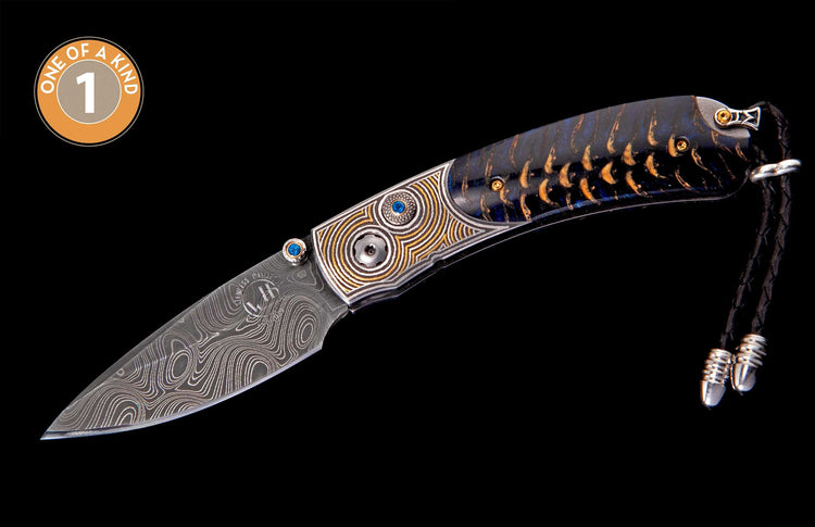 Damascus steel knife with an ornate handle featuring blue and brown patterns, intricate gold details, and blue gems, completed with a braided black leather lanyard.