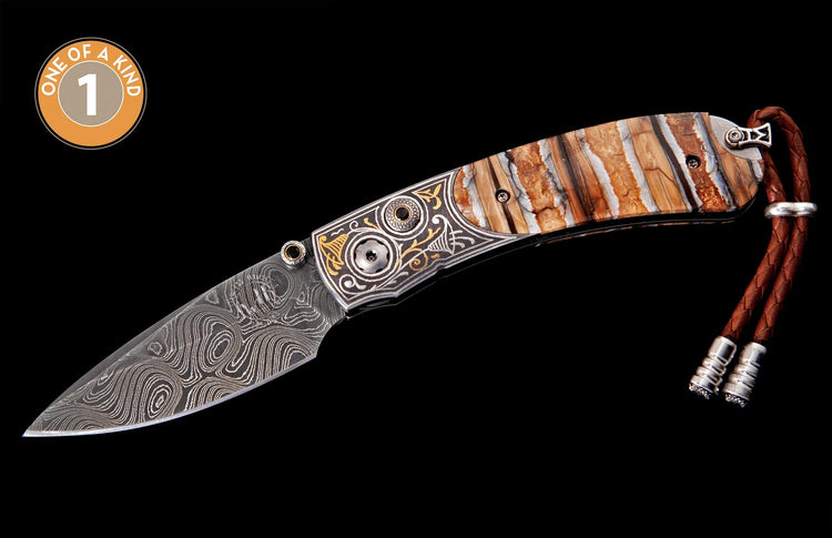 Elegant folding knife with swirling Damascus steel blade, layered brown and white handle, ornate engraved silver and gold accents, and a braided brown leather lanyard.