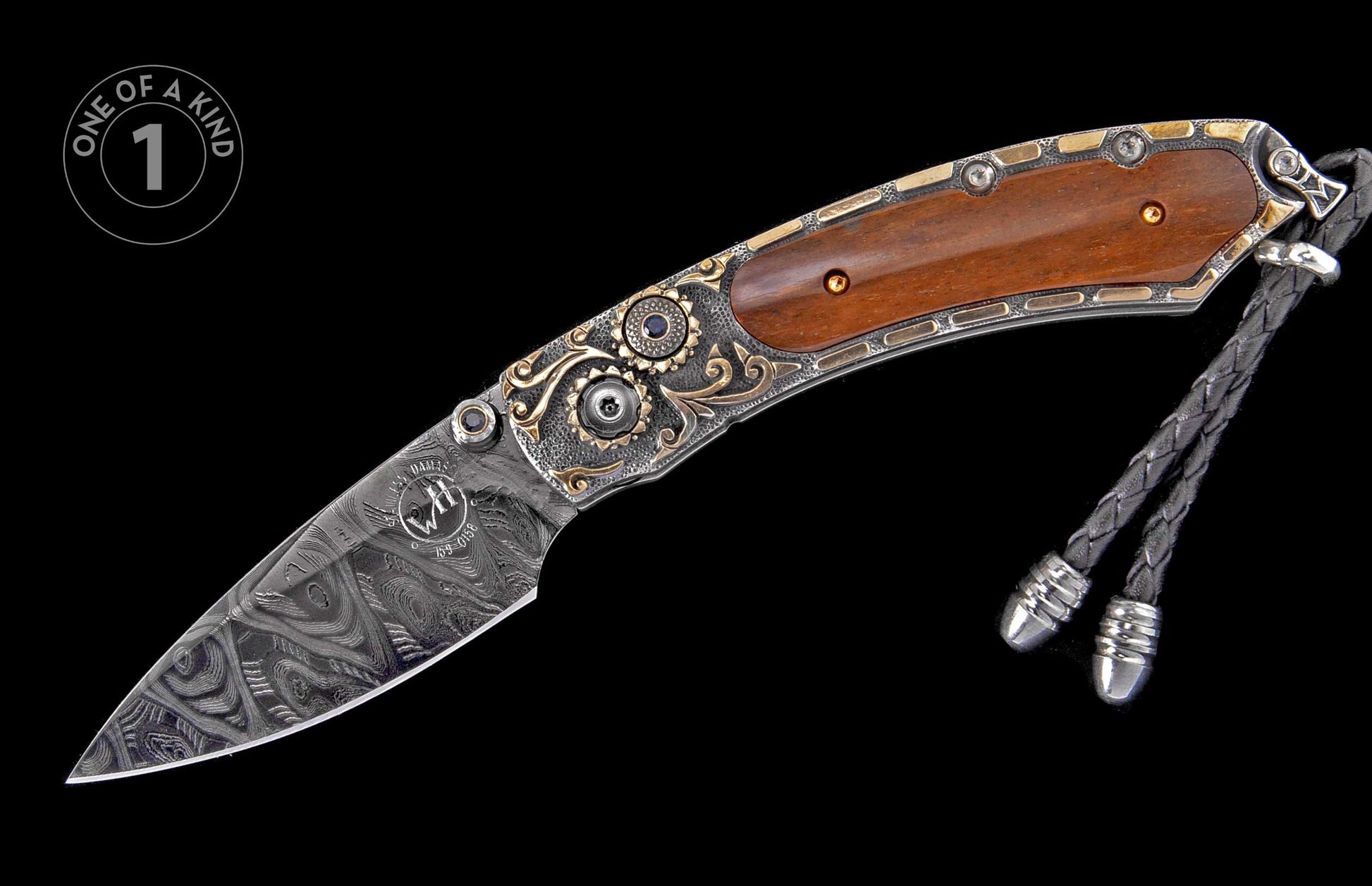 Ornate folding knife with a patterned Damascus steel blade, wood handle, intricate gold and silver-tone scrollwork, blue and gold gems, and a black leather lanyard.