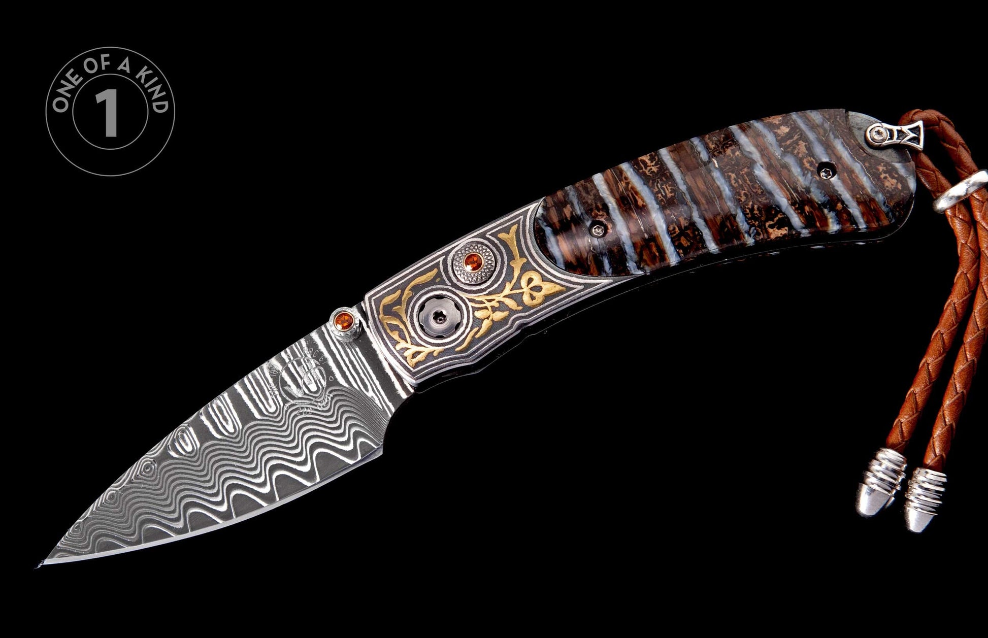 Folding knife with a wavy Damascus steel blade, patterned petrified wood handle featuring gold inlay and red gemstones, plus a braided leather lanyard.