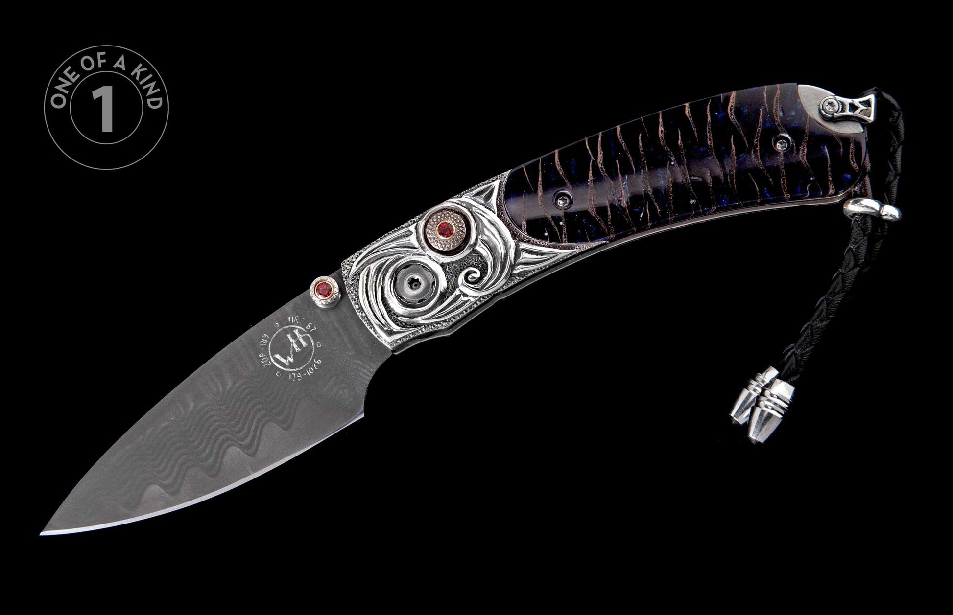 Decorative folding knife with a Damascus steel blade, ornate silver handle, red gemstone accents, and dark blue patterned grip.