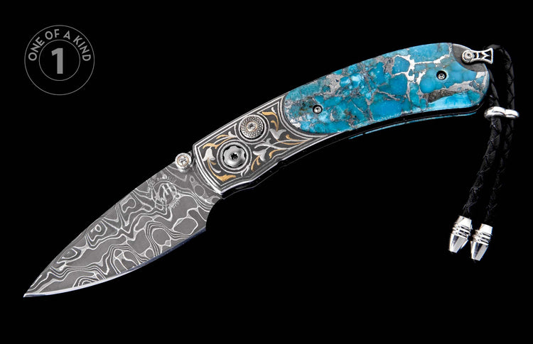 Folding knife with a wavy Damascus steel blade, bright blue turquoise handle, ornate silver and gold engravings, and a braided black leather lanyard.