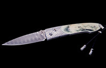 Custom folding knife with a wavy Damascus blade, cream handle engraved with an eagle and mountains, and a textured metal bolster.