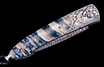 Salamander knife with a marbled blue and brown handle, featuring engraved silver and gold salamander and scrollwork, and a braided leather lanyard.