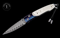 Folding knife with wavy Damascus blade, white carved handle featuring an eagle, and iridescent blue-purple patterned scales with a braided lanyard.