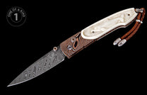 Folding knife with a patterned Damascus steel blade, layered wood and carved off-white handle depicting a figure, with a brown leather lanyard.