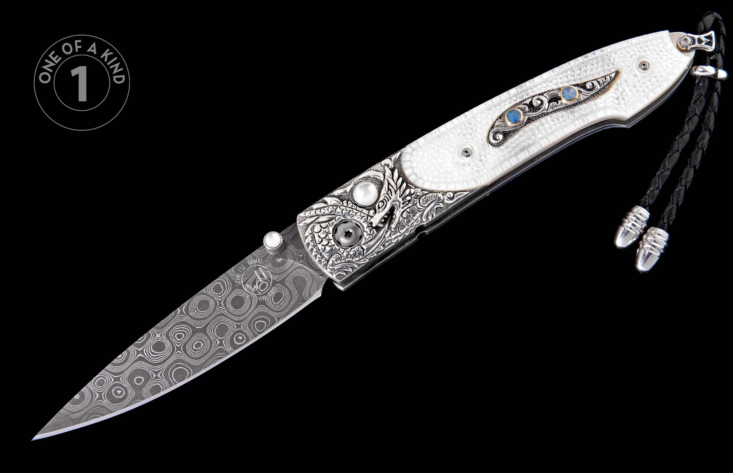 Folding knife with a white textured handle, intricate silver engraving, blue opal inlays, a patterned Damascus blade, and a black braided lanyard.