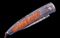 Custom folding knife with a Damascus steel handle and curly maple wood inlay, secured by screws, and a braided leather lanyard.