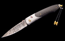 Folding knife with a textured Damascus steel blade, silver and carbon fiber handle with red and gold accents, and a black braided lanyard.