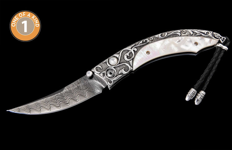 Ornate folding knife with a patterned Damascene blade, mother-of-pearl handle, engraved silver-toned details, pearl accents, and a braided cord.