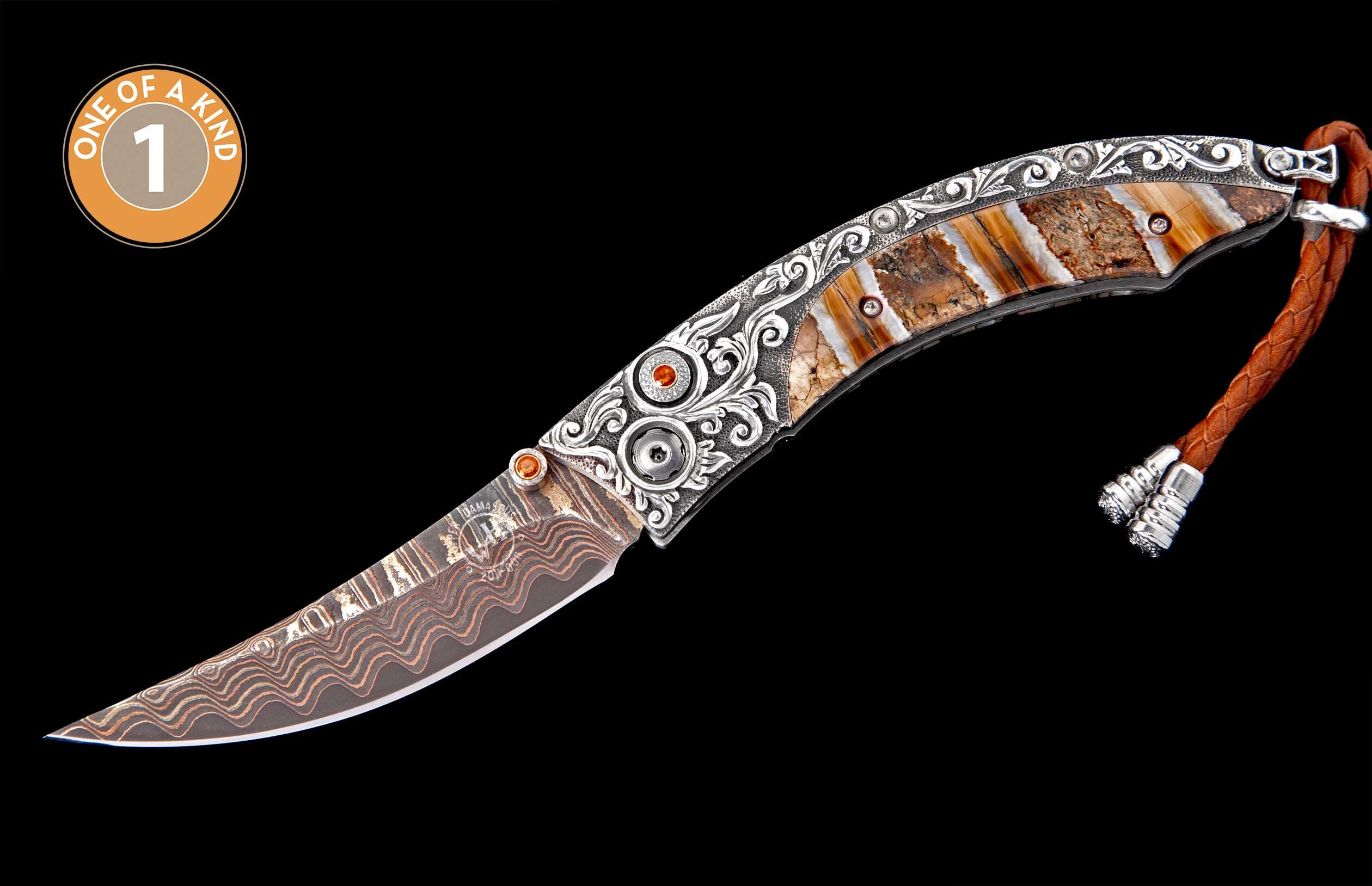 Luxury folding knife with wavy Damascus blade, engraved silver, bone handle with orange gems, and braided leather lanyard.