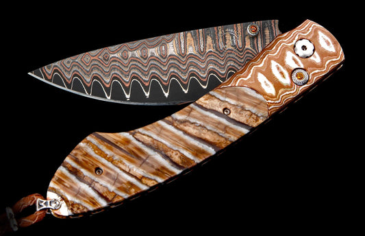 Custom folding knife with a wavy copper Damascus blade, striped fossilized handle, decorative gems, and leather lanyard.