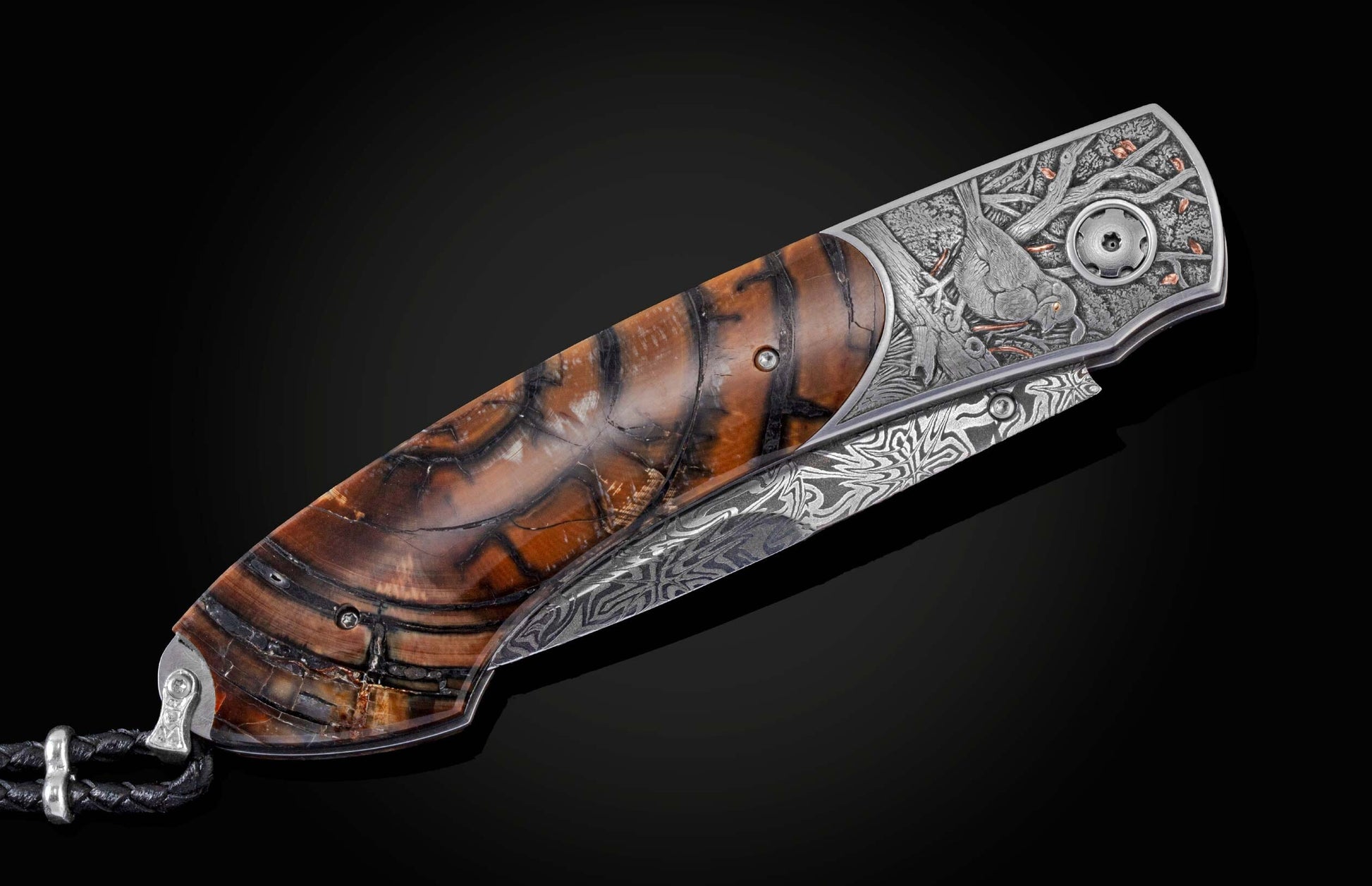 Candcrafted pocket knife from William Henry featuring hand-engraved grouse and quail with copper and 24K gold inlaid with fossil Woolly Mammoth tusk and set with spinel gem stones.. The blade is hand-forged damascus steel.
