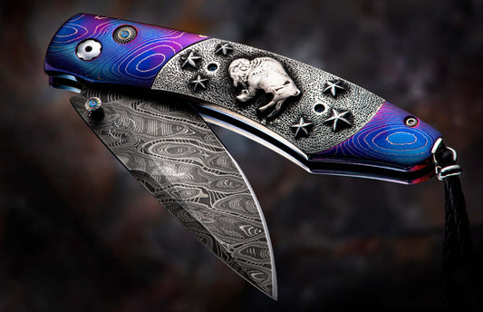 Artistic folding knife with blue and purple handle, silver buffalo, stars, blue gemstones, and a patterned Damascus steel blade.